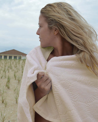 Girl on beach wrapped in Affina Hexo Bath Towel